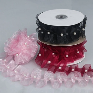 Detail of ruffled mesh lace ribbons with white pearls in black, burgundy, and pink colors