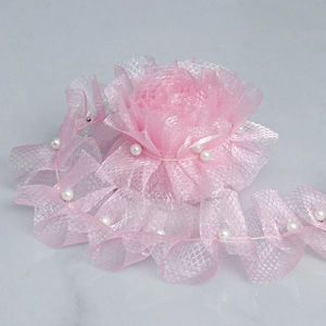 Detail of pink mesh grid lace trim with embedded white pearls for DIY sewing projects