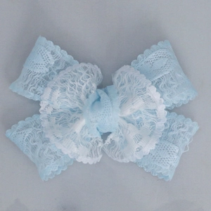 Detail of layered sky blue lace bow with intricate embroidery and delicate ribbon texture