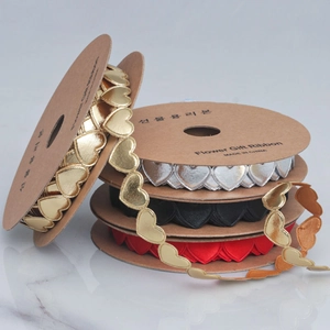 Detailed view of heart-shaped decorative gift ribbons in metallic gold, silver, red, and black