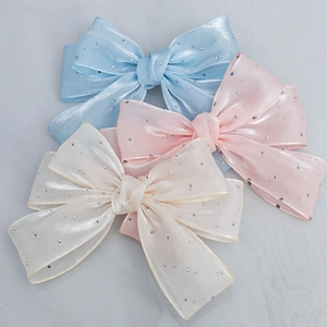 Détail de nœuds en fil de cristal double couche bleu, rose et beige avec strass brillants