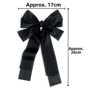 Detail view of a black silk bow hair clip with long ribbons, measuring 17cm by 26cm