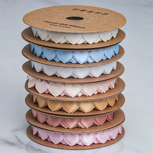 Detail of multi-color heart-shaped pleated satin ribbons on kraft paper rolls