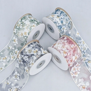 Close-up of translucent floral ribbons with cherry blossom prints and golden glitter