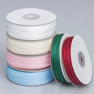 Macro view of multi-color grosgrain ribbons with ribbed texture on spools for DIY crafts