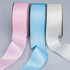 Macro detail of pink, blue, and cream grosgrain ribbons showing fine ribbed texture