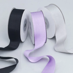 Detailed view of black, lavender, and white grosgrain ribbons with horizontal rib texture