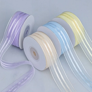 Detailed view of semi-transparent striped organza ribbons in purple, beige, blue and yellow