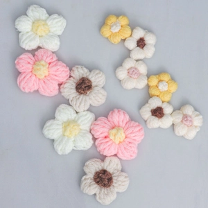 Macro detail of handmade crochet puff flowers in various colors for DIY craft accessories