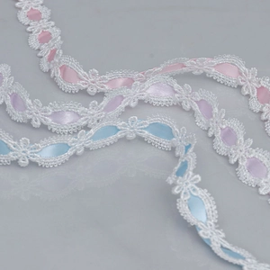 Detailed macro view of embroidered lace ribbons with woven pink, purple, and blue silk bands