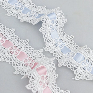 Detailed view of 4.5cm wavy water-soluble embroidery lace with pink and blue ribbons