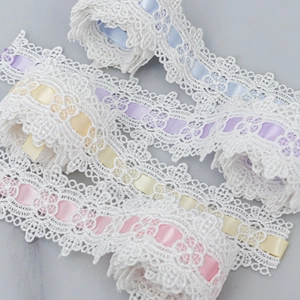 Detailed view of white polyester wave lace with colorful satin ribbons for DIY sewing