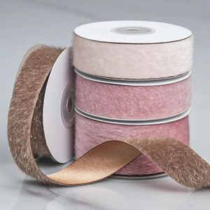 Close-up of faux fur ribbons in beige, pink and brown on marble for DIY hair bows