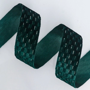 Macro detail of dark green velvet ribbon with silver metallic thread checkerboard pattern