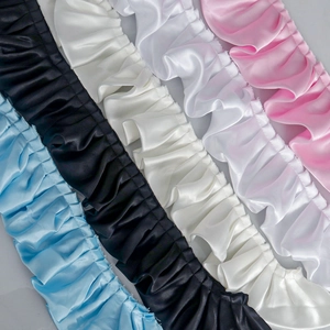 Nahaufnahme von Satin-Rüschen in Blau, Schwarz, Weiß und Rosa für DIY-Nähprojekte