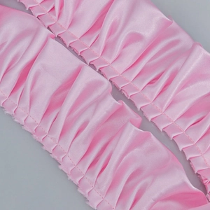 Makroaufnahme von 5cm plissierter rosa Satinspitze mit Rüschen und feiner Nahtführung