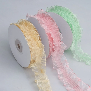 Detail of 3cm ruffled organza elastic ribbons in pastel yellow, pink and green rolls