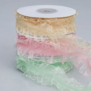 Close-up of three rolls of ruffled organza lace ribbons in yellow, pink and mint green
