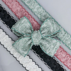 Close-up of wavy lace ribbons with bows in black, pink, mint green and white