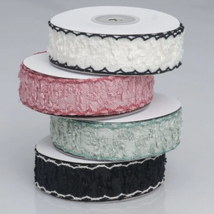 Detail of four colorful knit lace ribbons with wavy embroidery on paper spools