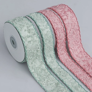 Macro shot of pink and green tufted texture ribbons with scalloped edges on rolls