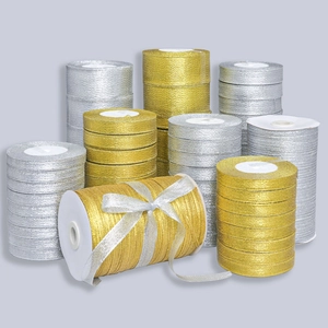 Dettaglio di nastri metallici oro e argento con fiocco decorativo e trama di tessuto a coste