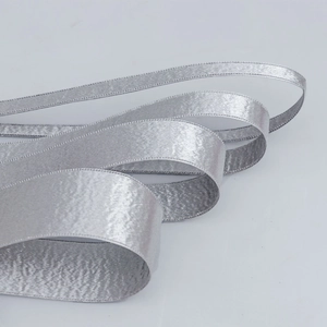 Close-up of double-edged silver glitter ribbon with premium satin texture for DIY crafts