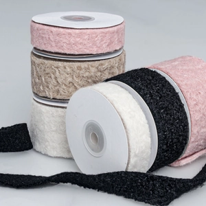 Detailed texture of wavy flocked ribbons in pink, beige, white and black colors