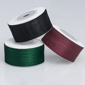 Close-up of 2.5cm matte sheer ribbons in black, dark green, and burgundy on spools