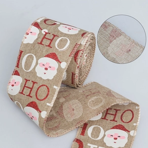 Detail of Christmas faux linen ribbon with Santa motifs and red glittery HO HO HO text