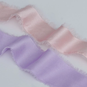 Detail view of light pink and purple chiffon ribbons with elegant frayed fringe edges