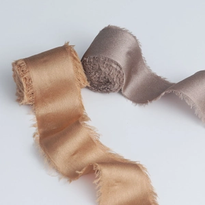 Detail of frayed edge chiffon silk ribbons in champagne and dusty pink for weddings