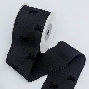 Detail of 5cm black velvet flocked bow patterns on twill ribbon roll for DIY crafts
