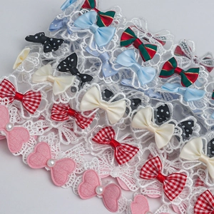 Close-up of assorted 3.5cm polyester lace bows with pearls for DIY doll clothing accessories