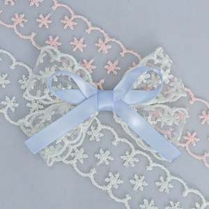 Detailed macro view of delicate lace ribbons and light blue satin bow decorations