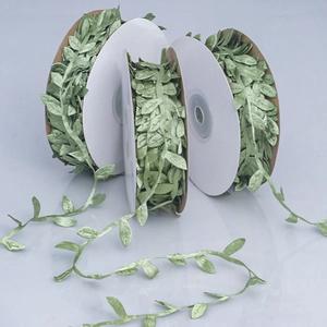 Close-up of green artificial leaf ribbon rolls for DIY crafts and gift wrapping