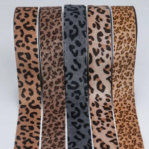 Macro detail of various leopard print ribbons in five shades for DIY bow hair accessories