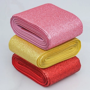 Detail of colorful glitter PU leather ribbons in pink, gold, and red for decoration