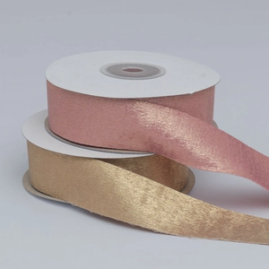 Detail of rose gold and champagne metallic satin ribbons for gift wrapping and DIY crafts