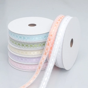 Rolls of colorful lace ribbons with satin center in pastel macaron shades for DIY crafts