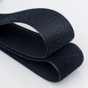 Black self-gripping hook and loop cable organizer for power cords on white background