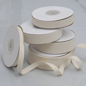 Detailed close-up of cream white cotton twill tape rolls with distinct woven textures