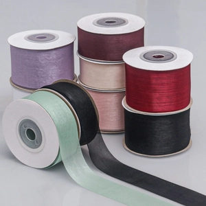 Detailopname van doorschijnende parelmoer organza linten in diverse kleuren op rollen