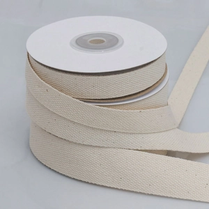 Natural white cotton herringbone twill tape ribbon neatly wound on a paper spool