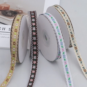 Detailed macro of four styles of 1cm floral scalloped embroidered ribbons for DIY sewing