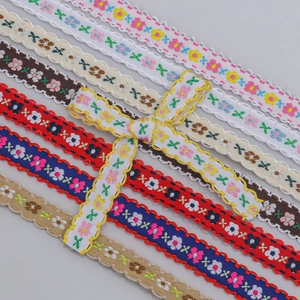 Close-up of 1cm floral embroidered ribbons with scalloped edges and decorative bow accent