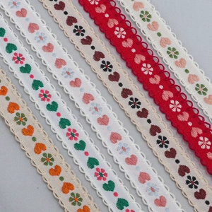 Detail of 15mm jacquard heart lace ribbons with floral embroidery and scalloped edges