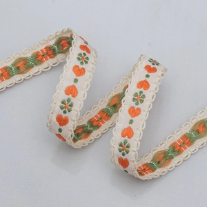 Detail of 15mm jacquard ribbon with orange embroidered hearts and floral patterns