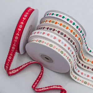 Detailed close-up of 15mm jacquard ribbon featuring heart and floral embroidery patterns