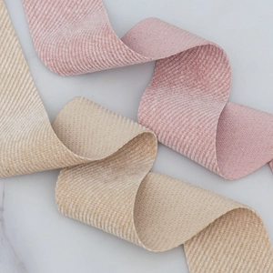 Pink and champagne corduroy ribbons with ribbed texture on marble surface background